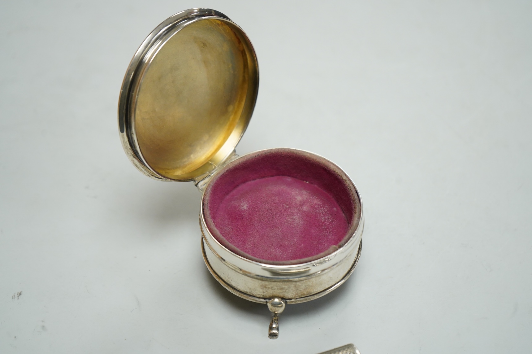 A George V silver mounted circular trinket box by Horton & Allday, Birmingham, 1916, diameter 75mm, together with a 19th century German? white metal vesta case and a modern silver wine label.